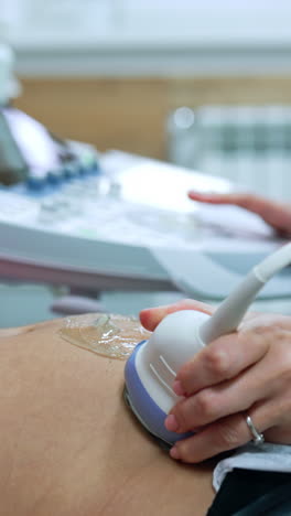 woman is visiting a doctor at early stages of pregnancy. pregnant is having ultrasonic check up. vertical video
