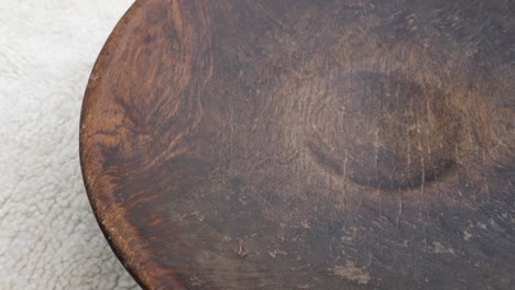 antique round wooden bowl on a traditional moroccan berber carpet.