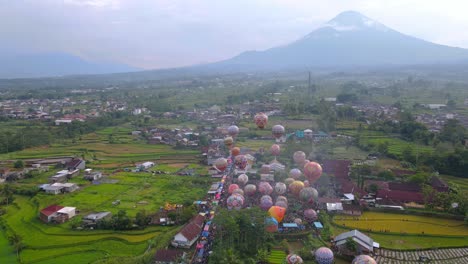 Aerial-view-of-Colorful-air-balloon-floating-on-the-air-with-view-of-rural-landscape-and-mountain-on-the-background