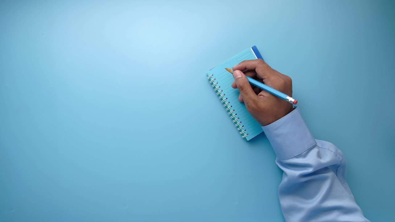 Person taking notes with a pen and notebook