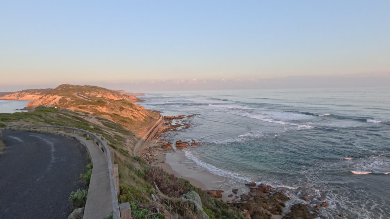 해가 지는 동안 바다의 파도와 함께 경치 좋은 해안 도로