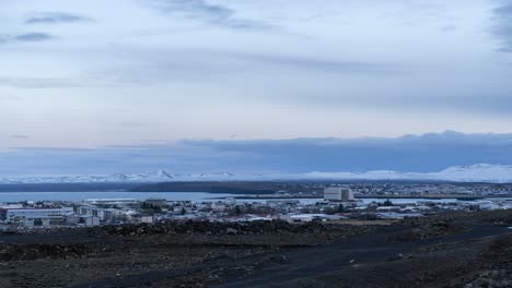 winter cityscape with snow-capped mountains and bay