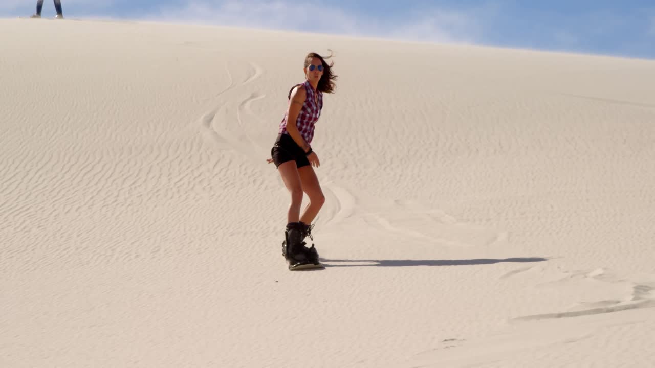 mujer a bordo de arena mientras el hombre la mira 4k