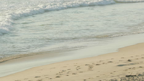 Bright-white-waves-rolling-over-an-empty-beach--Figueira-da-Foz-City,-Portugal