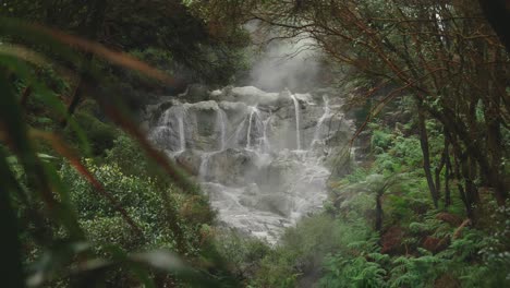 Breathtaking-slow-motion-of-raw-steamy-water-over-rocks-in-New-Zealand-forest-Rotorua,-geothermal