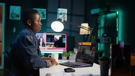 woman attending an online meeting at night in home office