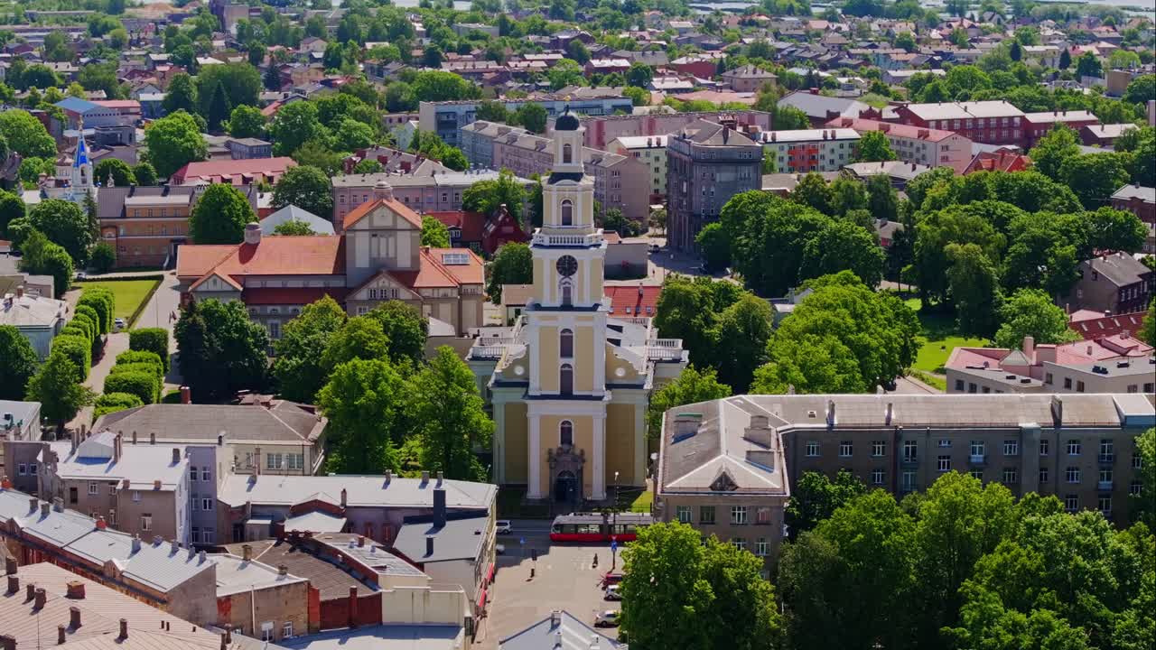 Aerial of Liepaja city streets highlighting Trinity Cathedral and passing tram