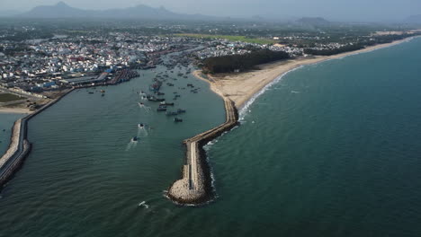 Aerial,-breakwater-structure-protecting-fishing-harbor-in-Southeast-Asia-from-rising-sea-levels