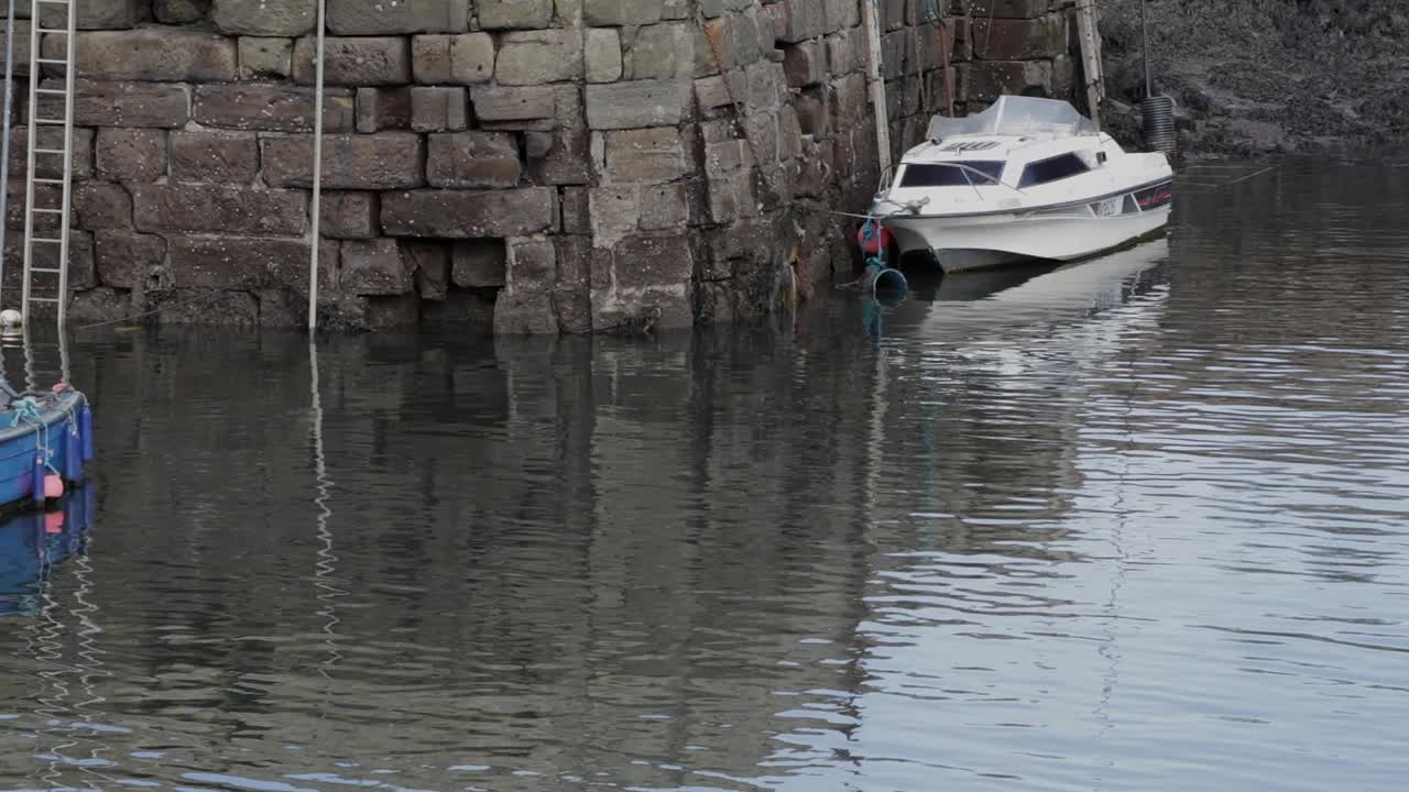 белый катер и синий катер на якоре в гавани во время отлива