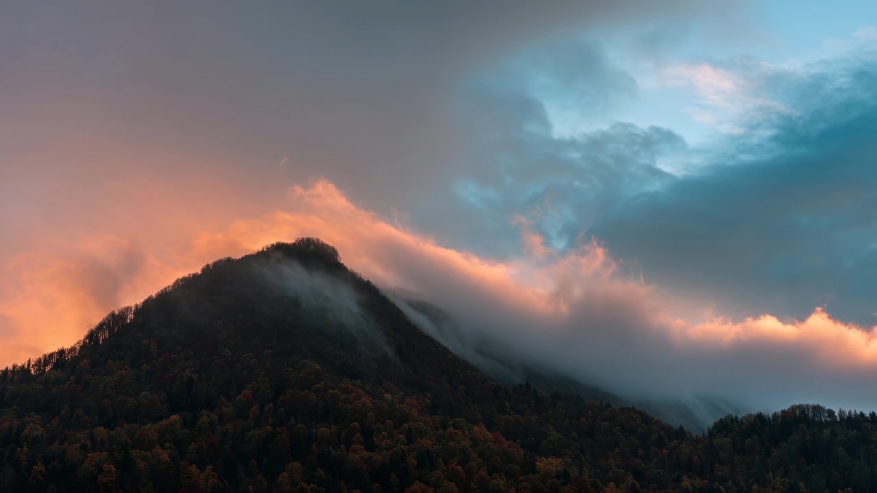 Clouds Moving Over Mountain Peak at Sunset