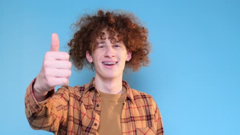young european man wearing casual shirt pointing finger up isolated on plain blue studio background young european man wearing casual shirt pointing finger up isolated on plain blue studio background