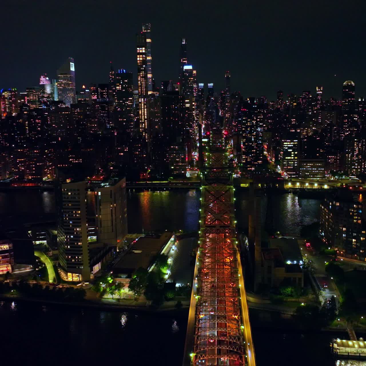 Wonderful Queensboro bridge crossing little island and East River. Amazing cityscape of New York at night time