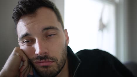 young burnt out white man falls asleep while watching tv, daytime