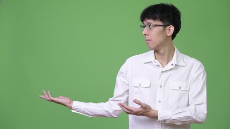 젊은 아시아 사업가 으로 무언가를 보여주고