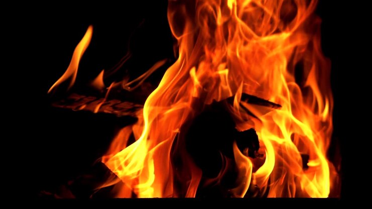 Legna ardente e luminosa in slow motion. Fiamma di fuoco. Falò.