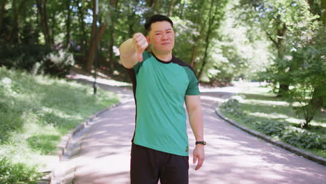 upset sportsman showing thumbs down dislike gesture expressing discontent disapproval dissatisfied