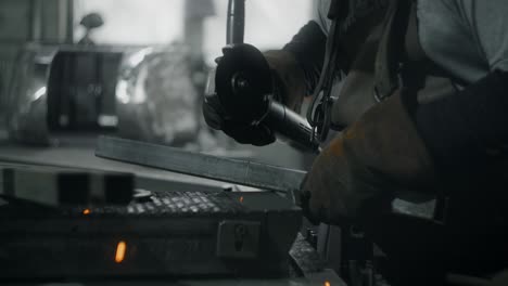 worker cuts a metal profile with a grinder in slow motion with a flying stream of sparks, metalwork in blacksmith's workshop, 4k 60p prores hq