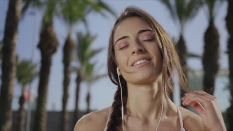 mujer poniendo auriculares en el parque. chica escuchando música en auriculares al aire libre