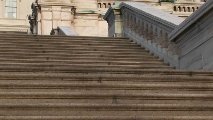 Guardando su per i gradini dell'edificio del Campidoglio degli Stati Uniti a Washington D.C., con una vista finale della cupola del Campidoglio