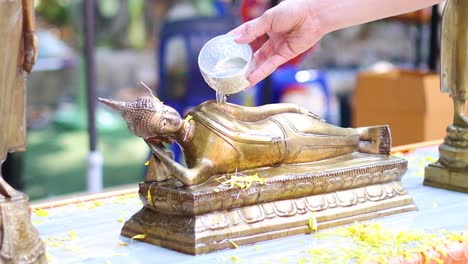 sequential pouring of water over a religious statue