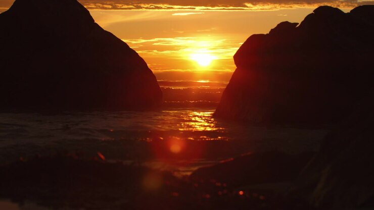 Sunset at a beach, where the sun in shining over the horizon and waves coming into the beach
