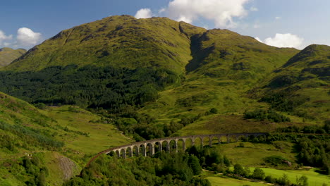 Aufsteigende-Drohnenaufnahme-Der-Berühmten-Eisenbahnbrücke-Im-Glenfinnan-Viadukt