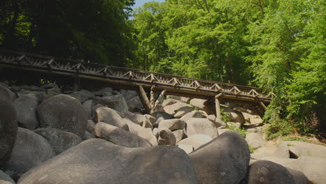 Felsenmeer-in-Odenwald-Sea-of-rocks-with-bridge-Wood-Nature-Tourism-on-a-sunny-day-steady-shot