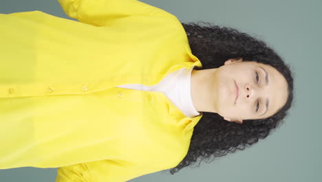 vertical video of young woman meditating looking at camera.