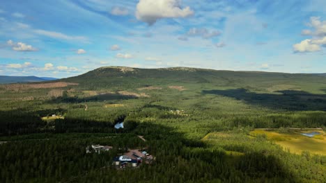 green mountain, lush vegetation and blue cloudy sky in sälen, dalarna, sweden - aerial drone shot