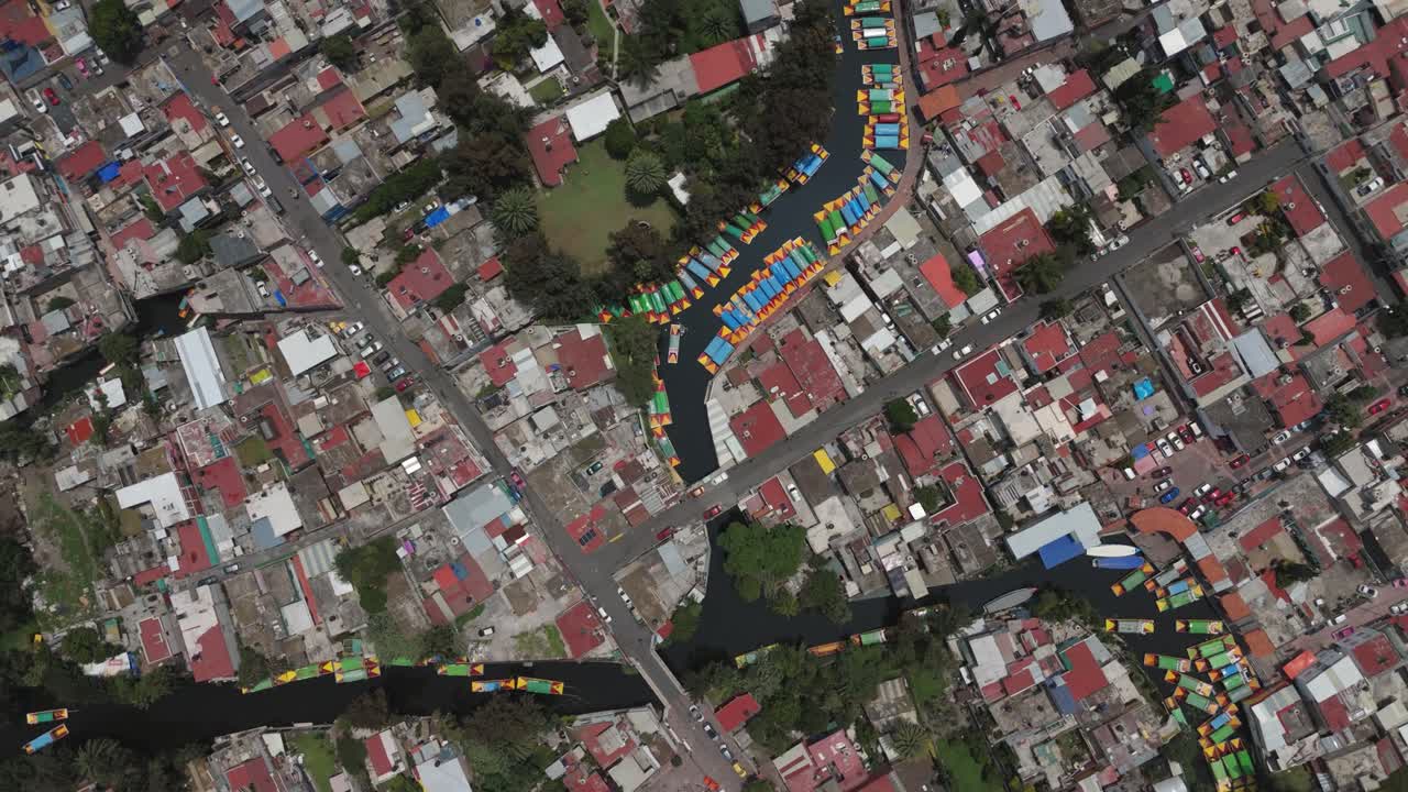 Drone view of trajineras and canals at a Xochimilco pier. CDMX
