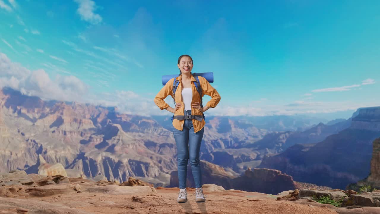 Full Body Of Asian Female Hiker With Mountaineering Backpack Smiling And Posing Arms Akimbo While Traveling At The Top Of Mountain
