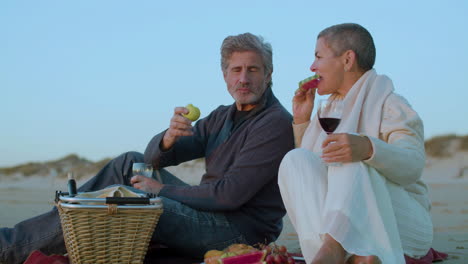 Happy-senior-Caucasian-couple-having-a-picnic-on-the-beach