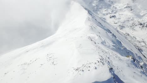 snowy mountain peaks with clouds