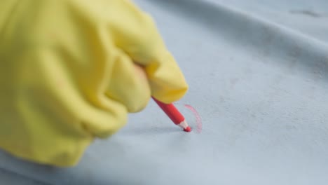 worker marking leather hides with a wax pencil in a leather factory in pakistan