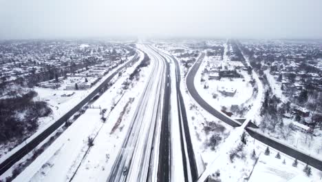 snow covered highway through dense suburban residential area