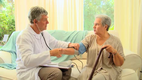 doctor chatting while taking his patients blood pressure