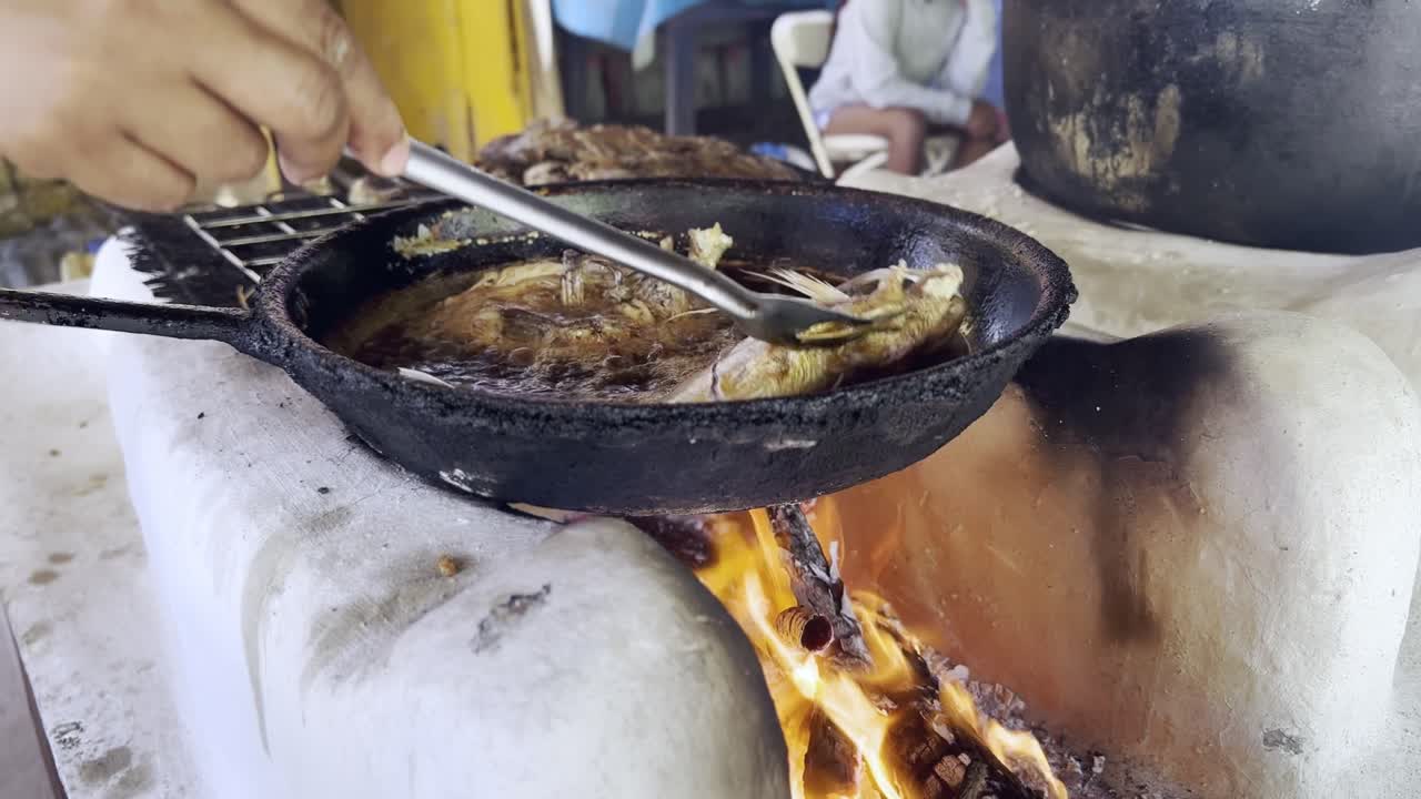 preparación de pescado frito en leña, república dominicana