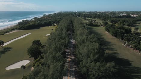 Drone-view-of-highway-between-the-pine-trees-and-near-the-beachside-golf-course