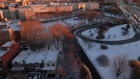a push-forward drone shot of a snowy highway entrance and a park blanketed in snow. the drone moves steadily forward.
