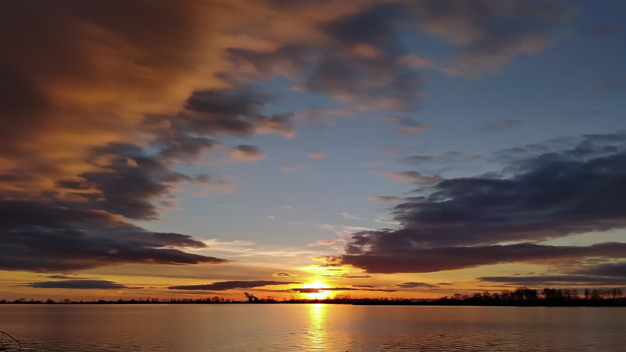 낮과 밤의 시간 경과 태양은 호수 위의 우울한 하늘에서 구름 속에서 움직입니다.