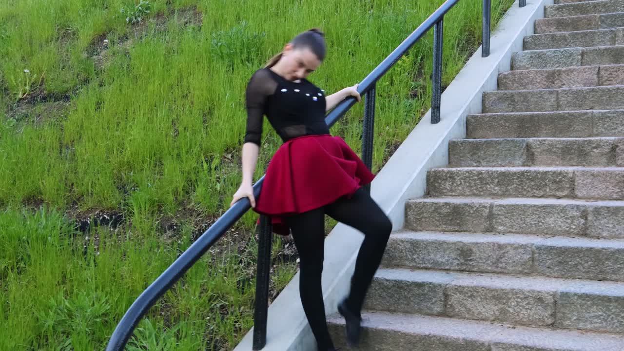 Una bella ballerina esegue una coreografia all'aperto sulle scale.