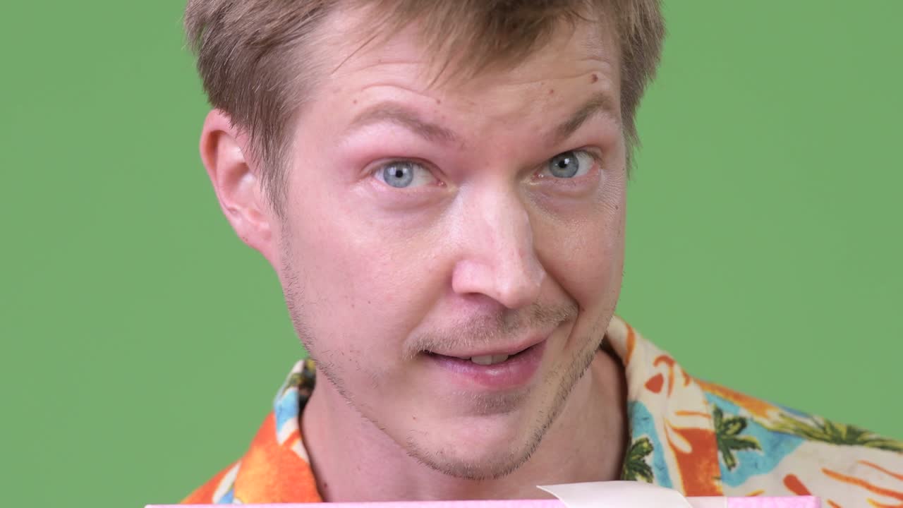 Young handsome tourist man smiling while giving gift box