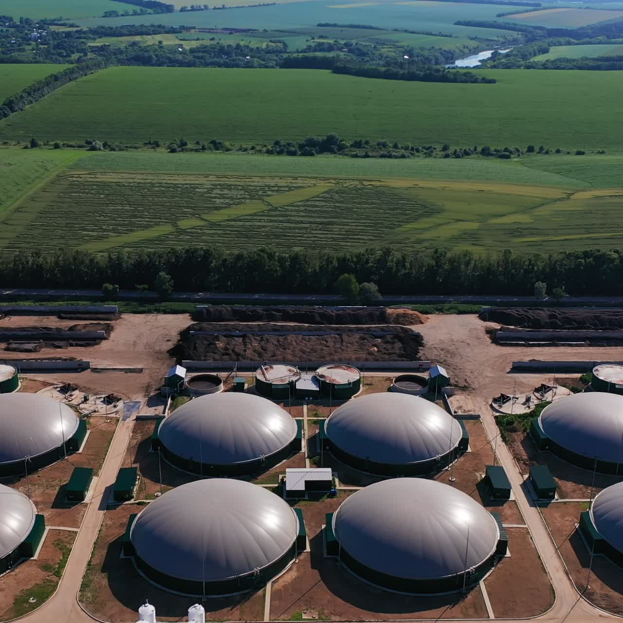 Hemispheric tanks for biogas production at the modern plant. Safe ecology plant in the green farmlands. Aerial view