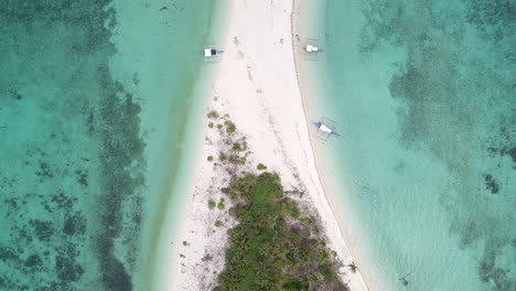 vista aérea de arriba hacia abajo de una isla con tres barcos locales filipinos