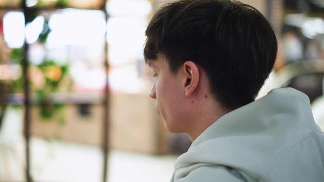 Back view of white man showing three dot marks near neck area while sitting in indoor setting with soft focus background, subtle lighting highlighting skin details and hairline