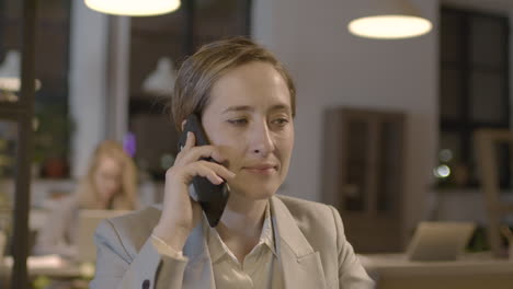 retrato de una mujer de negocios sonriente hablando por teléfono móvil en la oficina