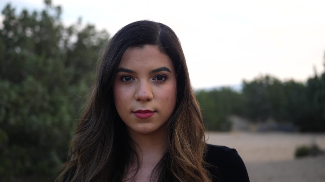 atractiva joven hispana adulta independiente que mira fuerte y seria a la cámara con confianza y determinación para el futuro de la humanidad