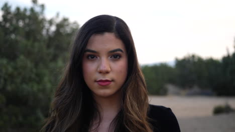 atractiva joven hispana adulta independiente que mira fuerte y seria a la cámara con confianza y determinación para el futuro de la humanidad