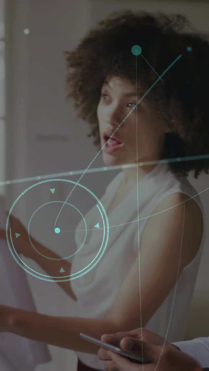 Vertical video: Woman studying panel while man pointing tablet and causing HUD overlays for design