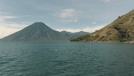 drone aerial view of beautiful lake atitlan, guatemala surrounded by volcanoes and mountains